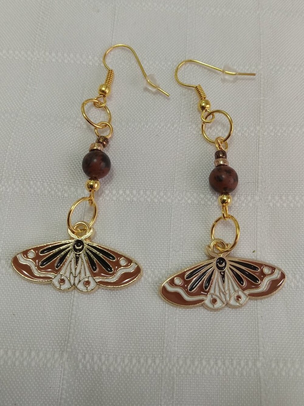 Handmade gold-colored earrings with multicolored enameled butterflies and beads